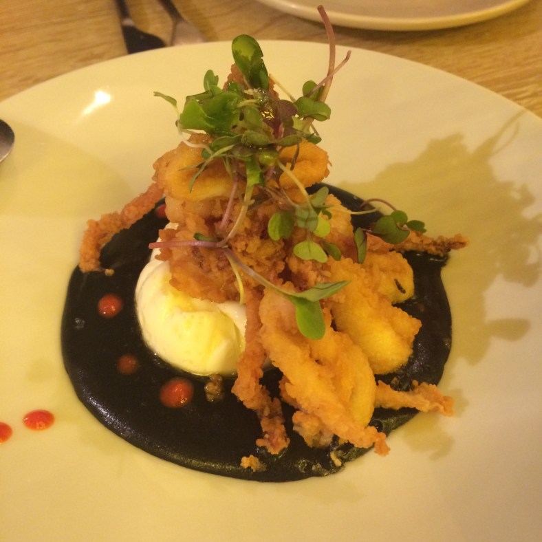 Cremoso de patata de tinta de calamar, huevo poché y patitas de chipirón