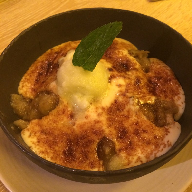 Manzana al josper, crema catalana y crumble de cítricos