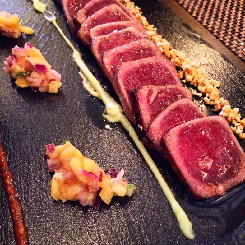 Tataki de atún almendrado acompañado de tartar de mango, mayonesa de wasabi y kimchi