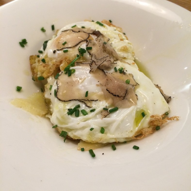 Huevos de corral ecológicos con patatas confitadas y trufa negra