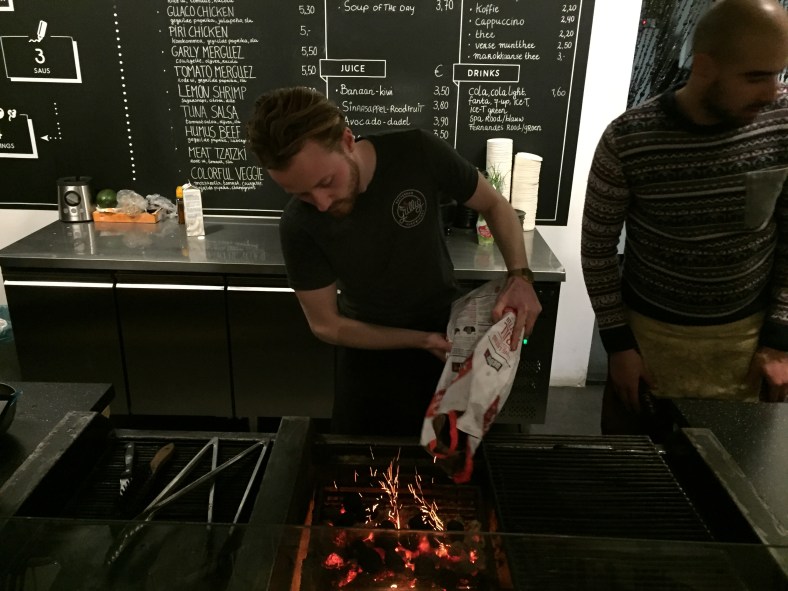 Uno de los dueños preparando las brasas