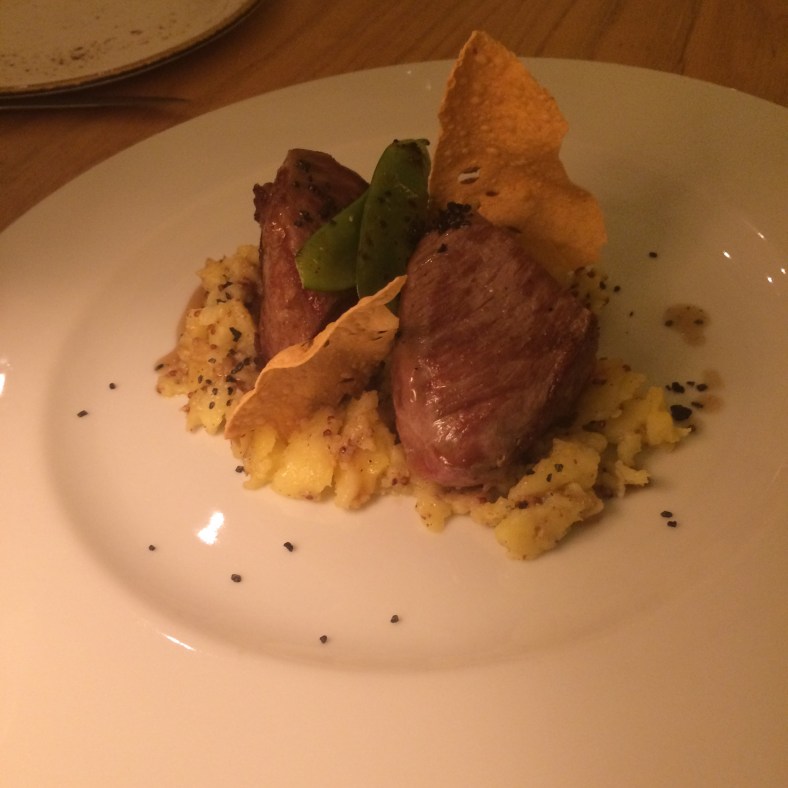 Presa ibérica con parmentier de mostaza, sal negra y unos chips orientales